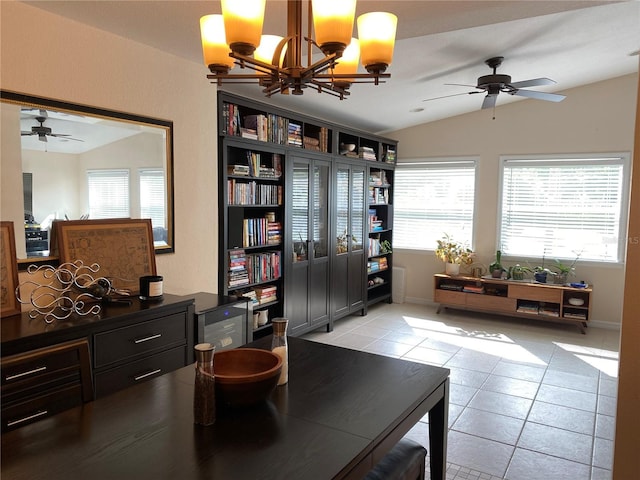 sitting room with ceiling fan with notable chandelier, light tile patterned floors, and vaulted ceiling