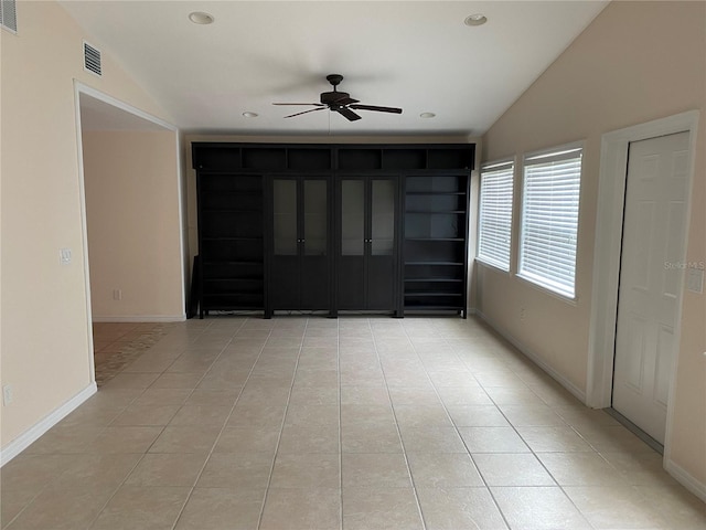 tiled empty room featuring ceiling fan and lofted ceiling