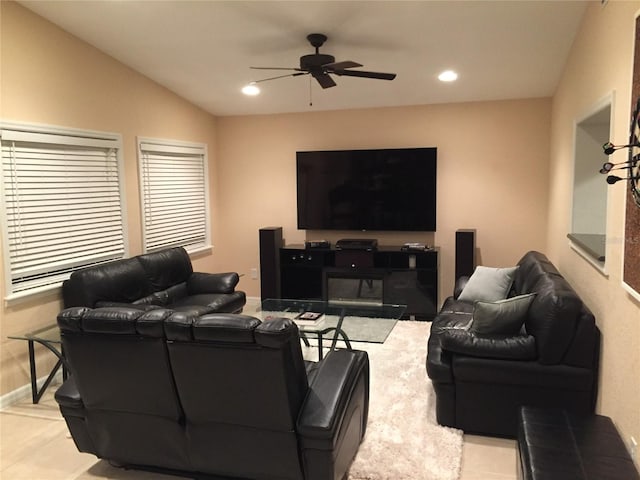 tiled living room with ceiling fan and lofted ceiling