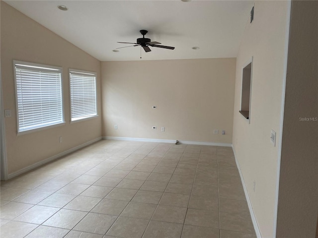 empty room with ceiling fan, light tile patterned flooring, and vaulted ceiling