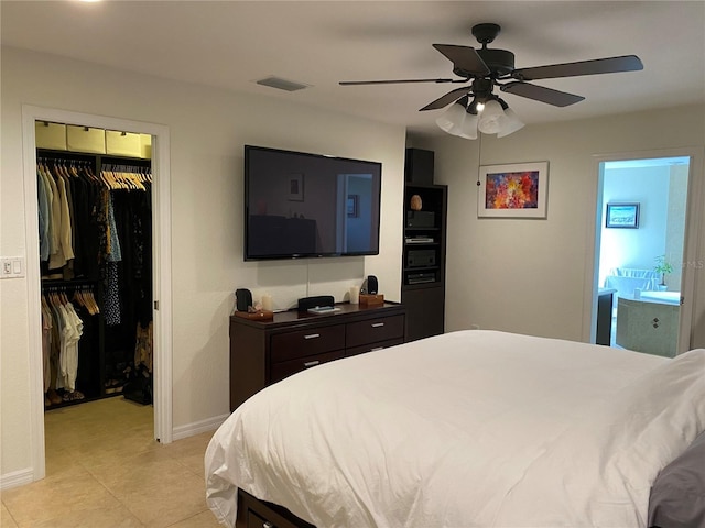 tiled bedroom with ceiling fan, a closet, and ensuite bath