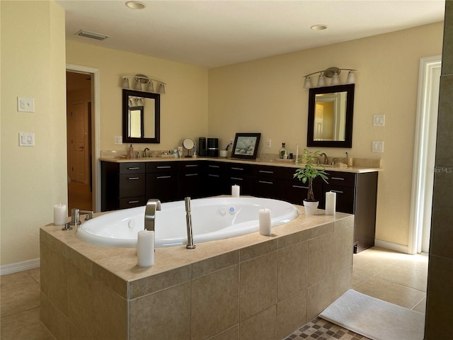 bathroom featuring tile patterned floors, tiled tub, and vanity