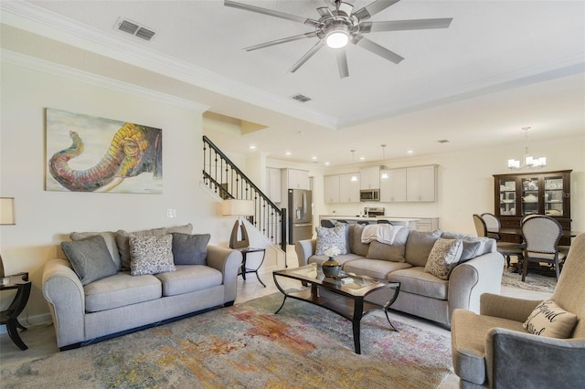 living room featuring ceiling fan with notable chandelier and ornamental molding