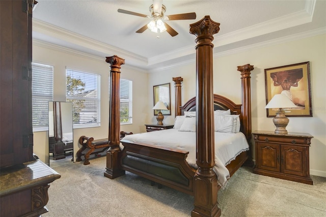 carpeted bedroom with ceiling fan, a raised ceiling, and ornamental molding