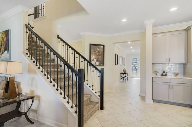 stairway with tile patterned flooring and ornamental molding