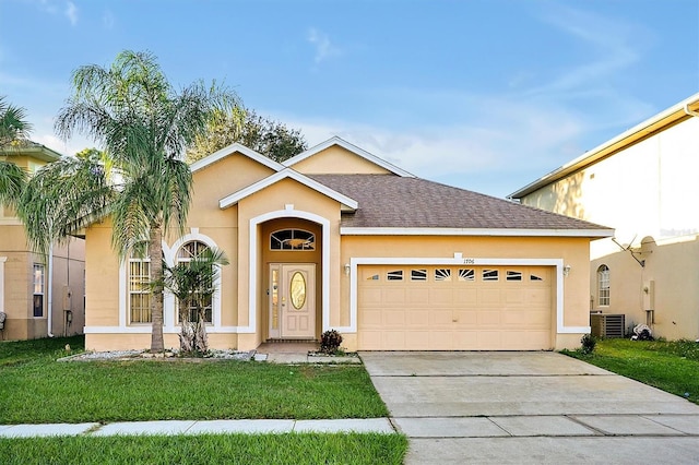 view of front of house featuring cooling unit, a front lawn, and a garage