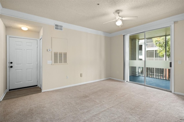 carpeted spare room with a textured ceiling, ceiling fan, and ornamental molding