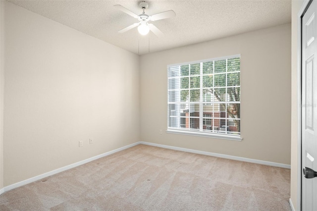 carpeted spare room featuring ceiling fan and a textured ceiling