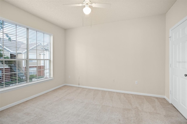 carpeted empty room featuring ceiling fan and a textured ceiling