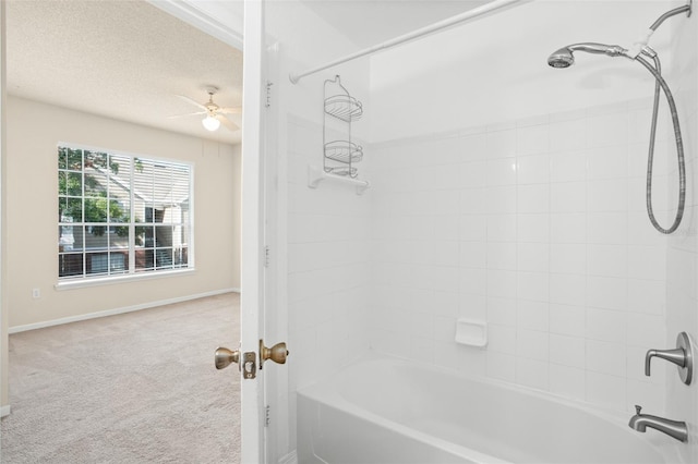 bathroom with a textured ceiling, ceiling fan, and tiled shower / bath