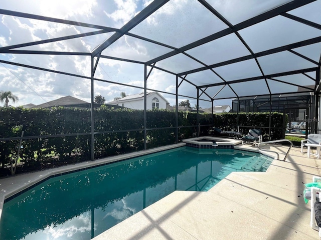 view of swimming pool featuring an in ground hot tub, a patio area, and a lanai