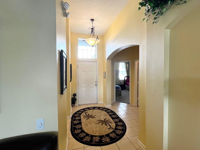 entryway with light tile patterned floors and a textured ceiling