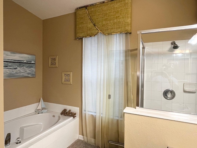 bathroom with separate shower and tub and a textured ceiling