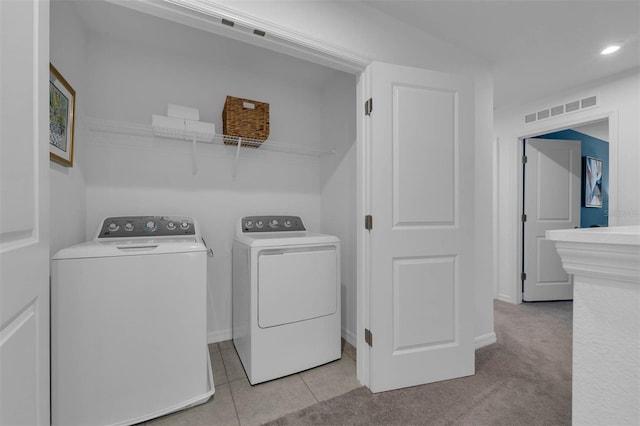 clothes washing area featuring washing machine and clothes dryer and light tile patterned flooring