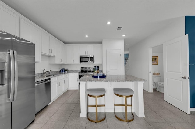 kitchen with white cabinetry, stainless steel appliances, and a center island