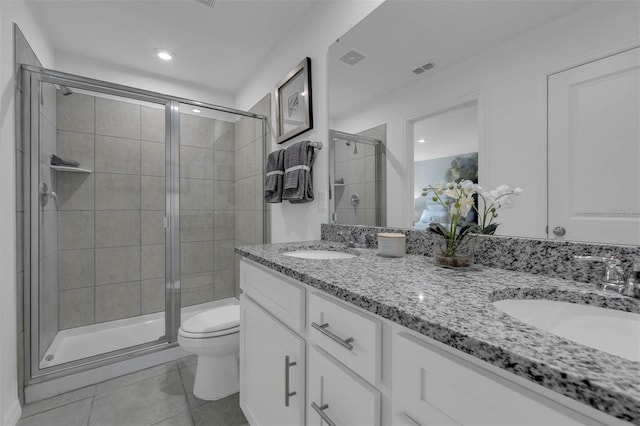 bathroom with a shower with door, vanity, tile patterned flooring, and toilet