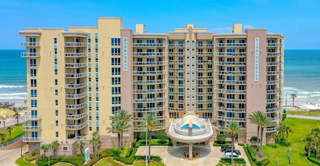 view of building exterior featuring a view of the beach and a water view