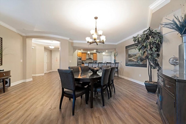 dining room with light wood-type flooring, ceiling fan with notable chandelier, and ornamental molding