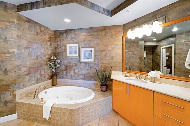 bathroom with tile patterned flooring, vanity, and a relaxing tiled tub