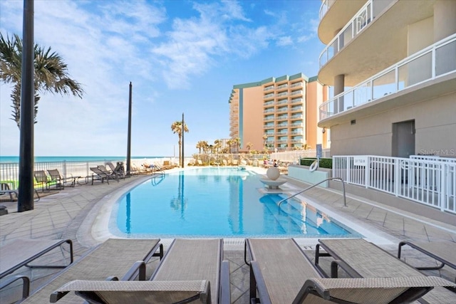 view of swimming pool with a water view and a patio