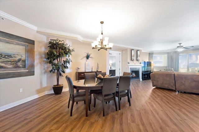 dining room with hardwood / wood-style flooring, ceiling fan with notable chandelier, and crown molding