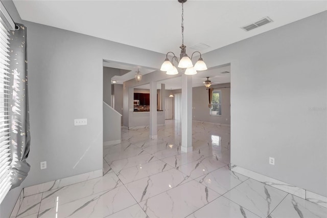 unfurnished dining area with ceiling fan with notable chandelier