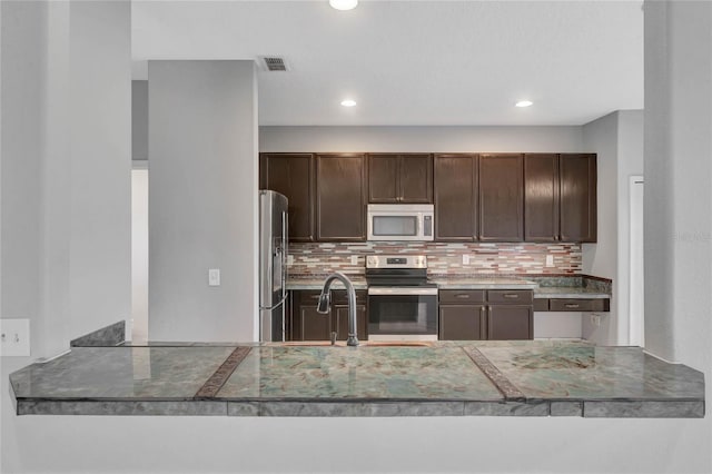 kitchen with backsplash, sink, dark brown cabinetry, and stainless steel appliances