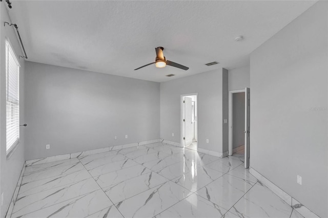 empty room featuring a textured ceiling and ceiling fan