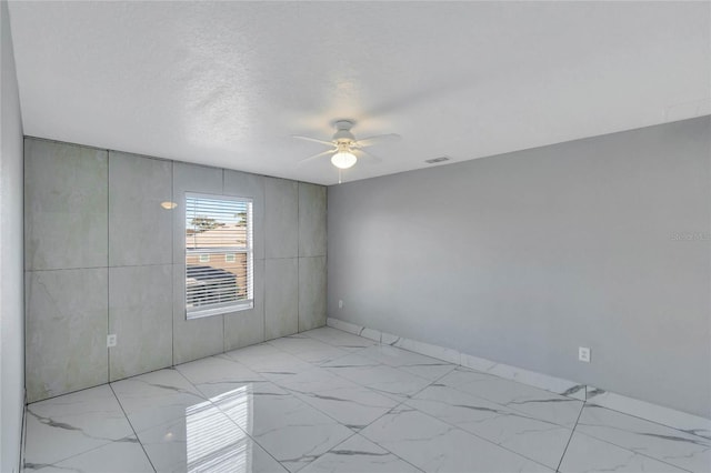 spare room featuring a textured ceiling and ceiling fan