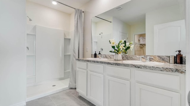 bathroom with a shower with curtain, vanity, and tile patterned floors