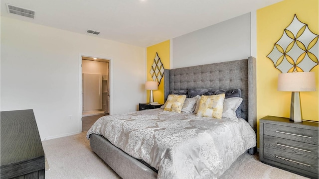 bedroom with light carpet and ensuite bath