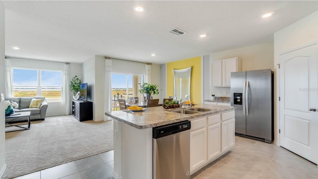 kitchen featuring sink, an island with sink, light carpet, white cabinets, and appliances with stainless steel finishes