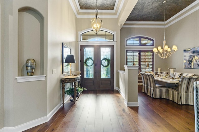 entryway with dark hardwood / wood-style flooring, a chandelier, french doors, and ornamental molding