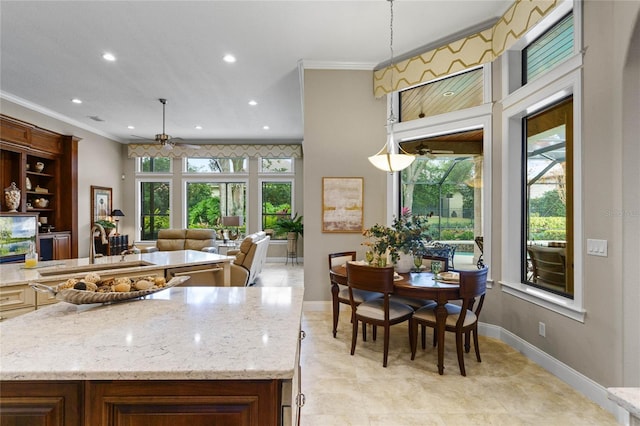 kitchen featuring a wealth of natural light, hanging light fixtures, crown molding, and sink