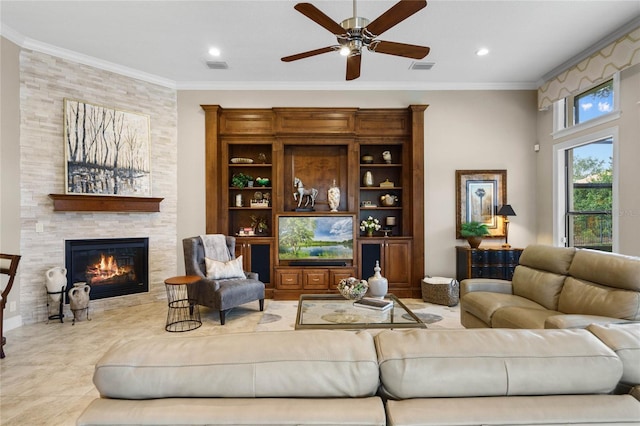 living room featuring a tile fireplace, ceiling fan, and ornamental molding