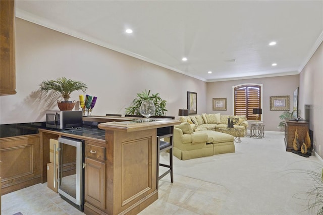 kitchen with a breakfast bar, light colored carpet, crown molding, and beverage cooler