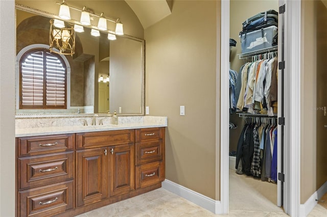 bathroom featuring tile patterned flooring, vanity, and lofted ceiling