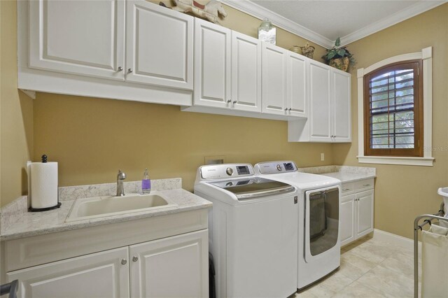 clothes washing area with washer and clothes dryer, cabinets, crown molding, sink, and light tile patterned floors