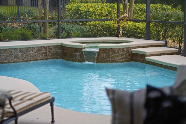 view of swimming pool featuring pool water feature and an in ground hot tub