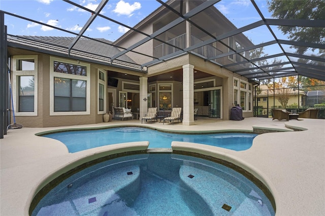 view of pool with an in ground hot tub, a lanai, and a patio area