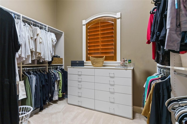 walk in closet featuring light carpet