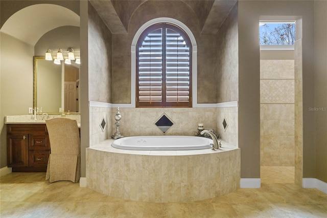 bathroom with vanity and a relaxing tiled tub