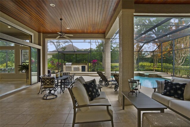 sunroom featuring plenty of natural light, ceiling fan, and wooden ceiling