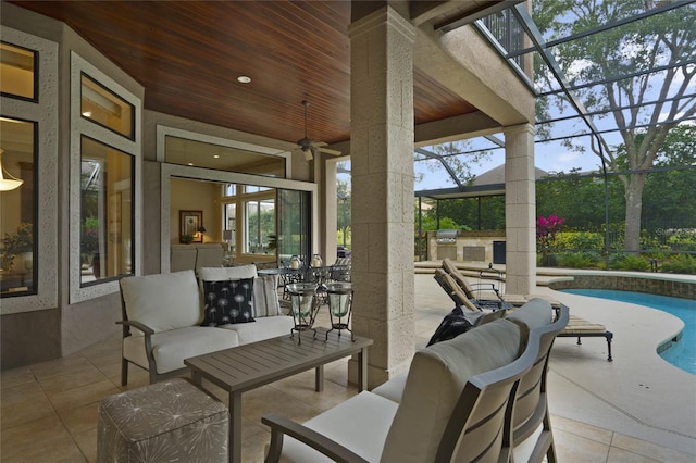 view of patio / terrace featuring a lanai, area for grilling, ceiling fan, and an outdoor living space