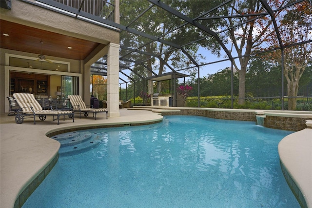 view of pool featuring glass enclosure, ceiling fan, and a patio area