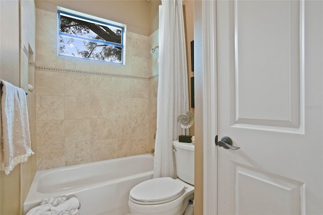 bathroom featuring toilet and shower / tub combo with curtain