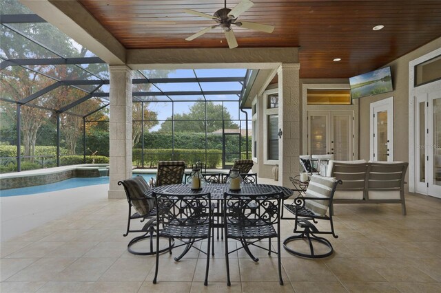 view of patio with a lanai, ceiling fan, and french doors