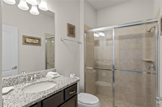 bathroom featuring vanity, a shower with shower door, and toilet