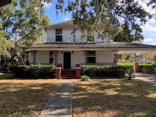 view of front of home with covered porch and a front yard