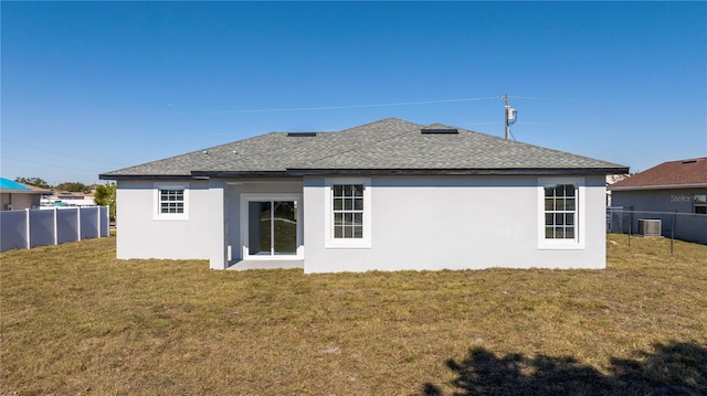 rear view of property featuring a lawn and cooling unit